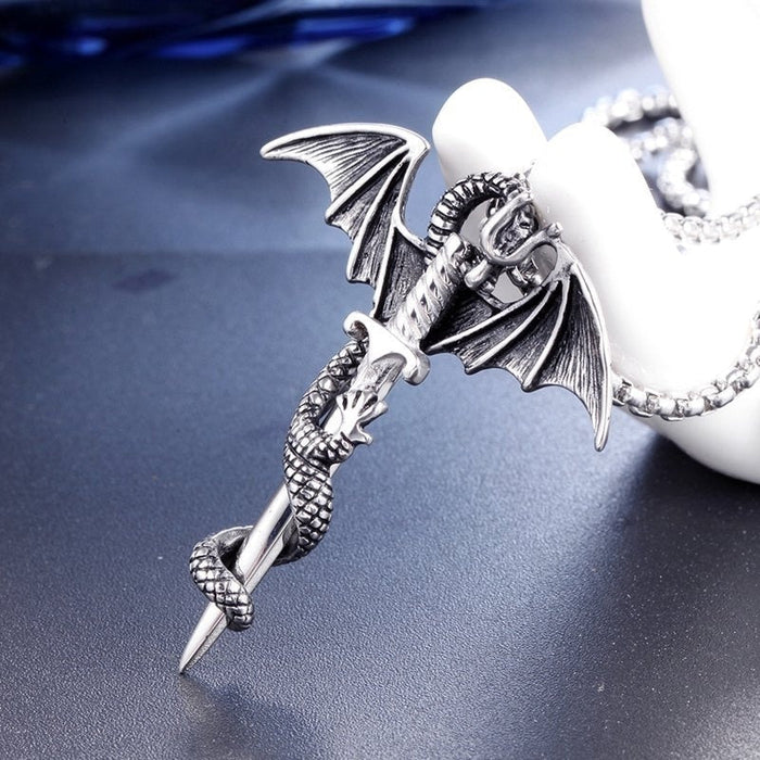 The Yellow Pandora Flying Dragon With Sword Necklace showcases a detailed flying dragon entwined around a silver alloy sword pendant. This exquisite piece is displayed on a silver chain and elegantly rests on a white mannequin hand against a dark background.