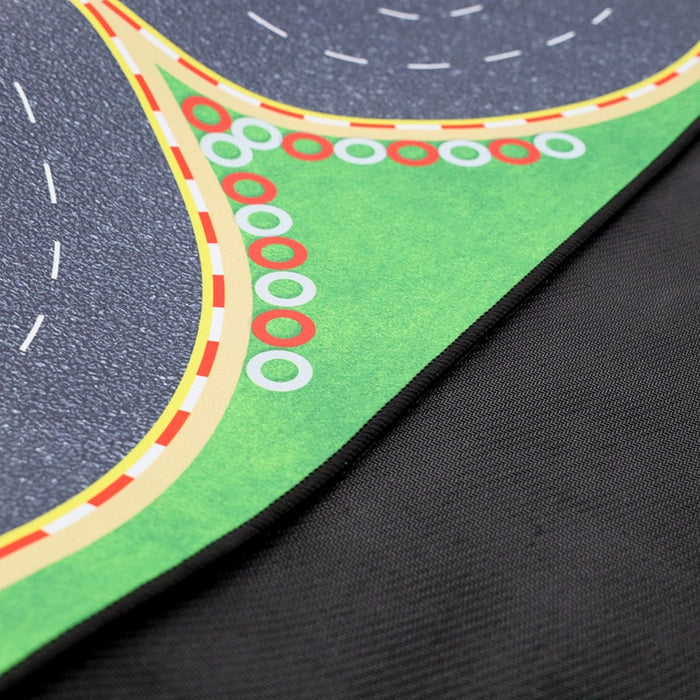 Close-up of the Turbo Remote Control Drift Car Track by Lacatang Shop, featuring a curved road with white dashed lines. Green grass and red and white circles enhance its edge, offering an exhilarating racing experience on black fabric. Suitable for all ages!.