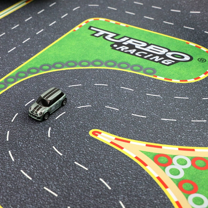 A small gray car with black stripes zooms on a "Turbo Drift Remote Control Car Track for Big and Small Scenes" by Lacatang Shop, featuring a racetrack mat labeled "TURBO RACING" with white dashed lines, curves, and colorful borders for thrilling drifting.