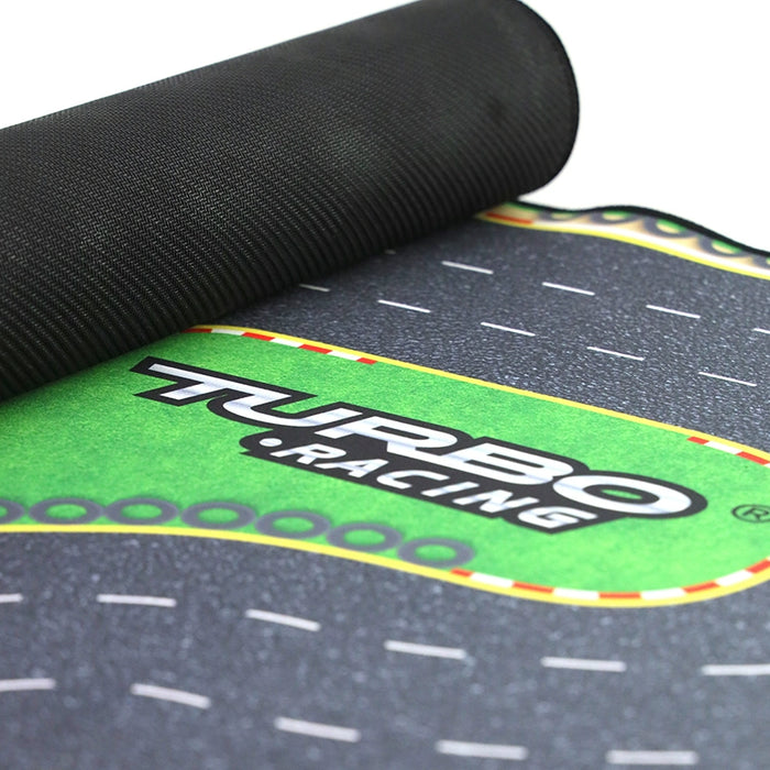 Close-up of a rolled black and green racing mat from Lacatang Shop with "Turbo Racing" on a stylized road, perfect for your Turbo Mini Drift Scene Remote Control Race Car Track. The textured surface has a colorful racetrack-like border for crafting your own mini drift scene.