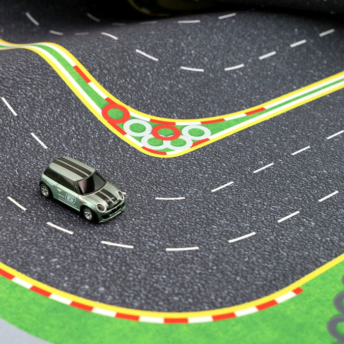 A gray toy car with black and white stripes races on Lacatang Shop's Turbo Mini Drift Scene track, a play mat featuring multiple lanes, colorful curbs, and a winding pathway that brings remote control car racing excitement to life.