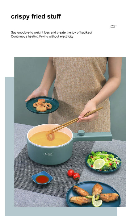 A person in a beige apron is holding a green plate with fried rings using chopsticks over a Lacatang Shop 2024 New Portable 1.5L Multi-function Pot Rice Cooker Electric Cooking Stir Frying Noodle Pot Mini Hot Pot, which is filled with yellow liquid. On the table are plates with fried chicken wings, cherry tomatoes, and lime slices. Text reads "crispy fried stuff.