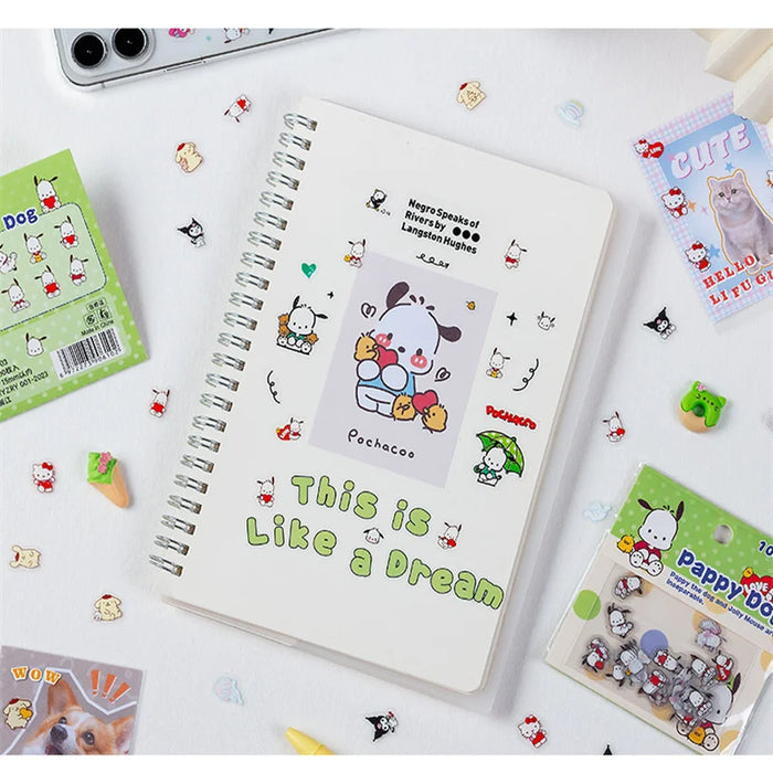 A spiral notebook sports a cute cartoon dog and "This is Like a Dream" text. It comes with AliExpress's 100-piece Sanrio Kawaii Sticker Set, featuring Pochacco, Kuromi, Melody, and Hello Kitty for playful dog-themed decorations.