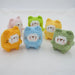 Six "Cute Cat Crochet Keychains" from Lacatang Shop, each in different colors: two orange, one pink, one blue, one green, and one light green. They are displayed together on a white background. Each cat has a square body and a cute facial expression, resembling miniature handmade jewelry pieces with charming details.