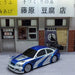 A blue and silver Lacatang Shop 2.4G RC Drift Car 1/43 4WD Remote Control High-Speed Mini Racing Car, complete with racing stripes, is parked in front of a Japanese tofu shop. The shop features a sign with Japanese writing and has two entrances: one adorned with a curtain and the other equipped with a glass door.