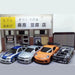 A display of the Lacatang Shop’s 2.4G RC Drift Car 1/43 showcases four high-speed, four-wheel-drive remote control racing cars side-by-side in front of a Japanese storefront facade. The blue car, silver car, orange car, and black and white patterned car each exemplify the thrilling performance these mini racing models are known for. The store sign includes Japanese text.