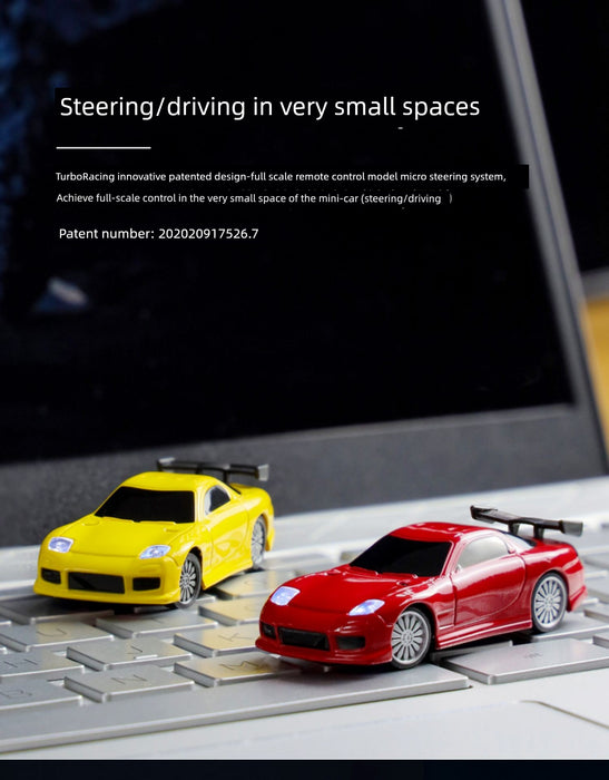 Two JDM Racing Miniature Toy Remote Control Sports Cars from Lacatang Shop, one yellow and one red, are displayed on the keys of a computer keyboard. The background features a black screen with text about the Turbo Racing innovative patented steering system for small-scale racing toys.