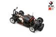 A close-up of a Lacatang Shop brand WLtoys 1:28 284131 284161 RC car chassis. The car features visible wiring, tires with rugged treads, and mounted components including a lithium battery pack, motor, and steering mechanism. Capable of reaching speeds up to 30KM/H, logos are displayed in the top right corner.