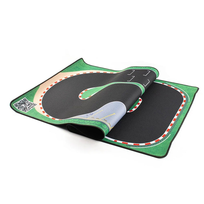 The Lacatang Shop Portable Turbo Racing Rubber Track Mat for 1:76 RC Cars, available in 160x90cm and 180x80cm sizes, features a winding road with red and white turn markings on a green field background for optimal grip. A QR code is visible on one corner.