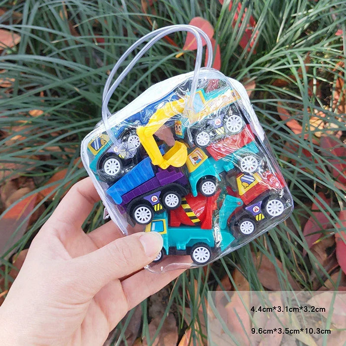 A hand holds a clear bag filled with vibrant toy vehicles, great for imaginative fun, featuring trucks and construction vehicles. Set against green plants, the scene shows vehicle dimensions in the corner. Product: Interactive City Traffic Play Mat by Lacatang Shop.