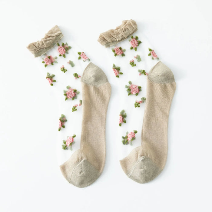 These vintage floral lace ruffle socks from Lacatang Shop feature beige toes and heels with delicate pink roses on a semi-transparent background. Topped with beige ruffles, these crystal silk crew socks blend Kawaii Harajuku style with elegance.