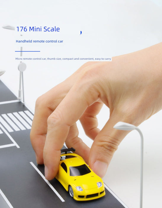 Close-up of a hand positioning a small, yellow racing toy on a miniature road. The text reads, "JDM Racing Miniature Toy Remote Control Sports Car by Lacatang Shop. Micro remote control car, thumb size, compact and convenient, easy to carry.