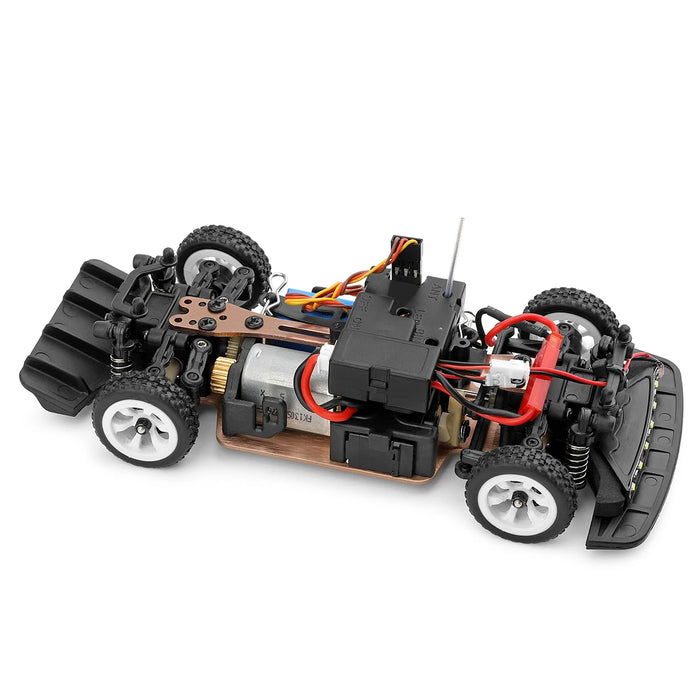 A close-up view of the intricate and detailed chassis of the WLtoys 1:28 284131 284161 Racing Mini RC Car by Lacatang Shop. The car is equipped with four black and white tires, visible mechanical parts, wiring, a small motor, a lithium battery for longer runs at speeds up to 30KM/H, and various electronic components. The chassis is elegantly mounted on a wooden base.