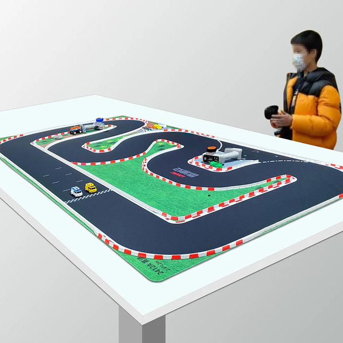 A child in a yellow jacket skillfully navigates an RC car on the intricate LDARC Mini RC Car Racing Track Mat from Lacatang Shop, with its red and white barriers captivating their focus as they master the toy.