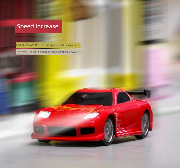 A JDM Racing Miniature Toy Remote Control Sports Car from Lacatang Shop is captured in motion, generating a blurred background effect. The text "Speed increase" hovers above the car, with additional text revealing that this Turbo.Racing toy is 2 times faster than a MINI car. The scene is set in a bright indoor environment with a colorful, out-of-focus backdrop.