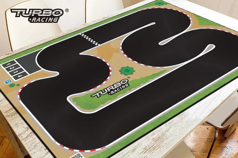 A Lacatang Shop Portable Turbo Racing Rubber Mat for 1:76 RC Mini Car Track is laid on a table, featuring black rubber with white borders, red accents, curved pathways, a checkered start/finish line, parking icons, and green patches. Multiple sizes available.