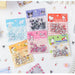 The 100-piece Sanrio Kawaii Sticker Set by AliExpress includes charming designs like Pochacco, Kuromi, Melody, and Hello Kitty. These nail art decorations come in six resealable packages on a white surface, perfect for student stationery and birthday gifts.