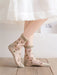 A person wears Lacatang Shop's Vintage Floral Lace Ruffle Socks for Women, Kawaii Harajuku style ultra-thin transparent crystal silk crew socks with pink rose patterns. They pair them with a white skirt against neutral-toned walls and wooden flooring, creating a serene backdrop.