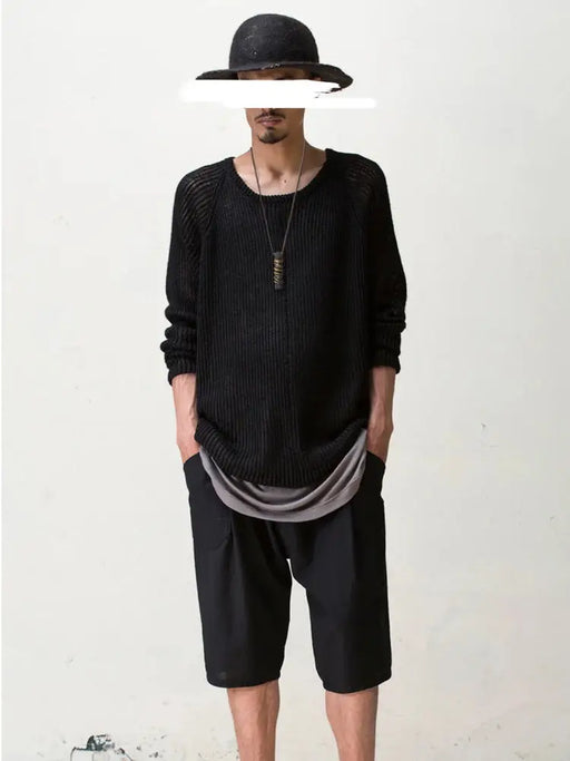 A person adorned with a black sweater, gray undershirt, and black shorts stands against a plain white backdrop, hands tucked into pockets. They wear a sleek black hat and their facial expression suggests contemplation, perhaps reflecting on the distinct style of their Lacatang Shop accessory: an Original Design Ebony Wood Pendant Male Temperament Retro Chinese Ethnic Style Necklace Woolen Chain Female Jewelry.