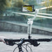 A smartphone is mounted on a sleek, stainless steel bicycle while displaying an image of a road with greenery. The handlebar and part of a person's hand are clearly visible in the foreground against the blurred background of an outdoor setting. This setup provides an ideal environment for using the 1 set Nose Hair Trimmer for Men Stainless Steel Manual Shaver from AliExpress.